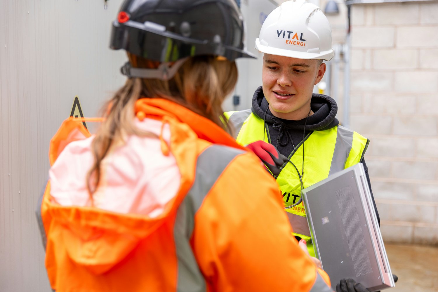 An engineer in hi-vis and a hard hat reviewing work on site